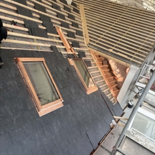 Tømrer udfører tømrerarbejde med renovering af tag og montering omkring ovenlys