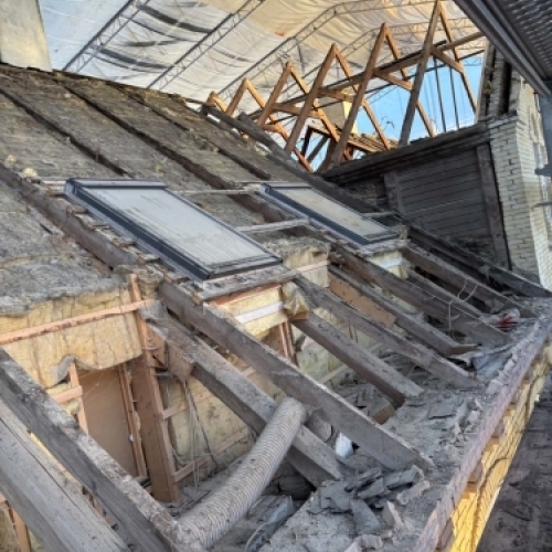 Tømrer udfører tømrerarbejde med tagdækning og opbygning af nyt tag