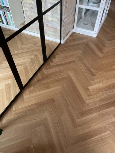 Snedkerarbejde med lægning af sildebensparket i bolig