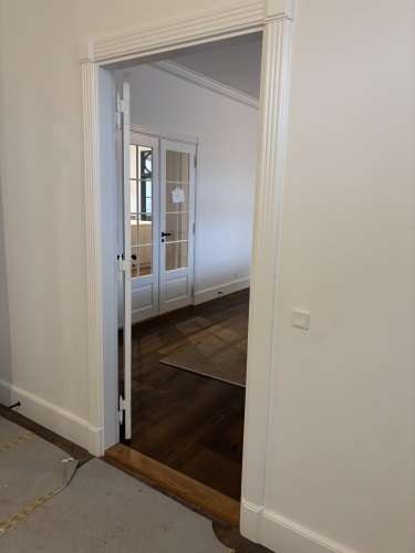 Tømrer udfører etablering af nyt dørhul og montering af karm som del af udskiftning af døre