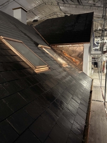 Tømrer udfører tømrerarbejde med nyt tag i Odense med ovenlysvinduer