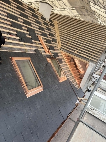 Tømrer udfører tømrerarbejde med renovering af tag og montering omkring ovenlys
