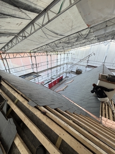 Tømrer udfører tømrerarbejde med reparation af tag og tætning ved samlinger