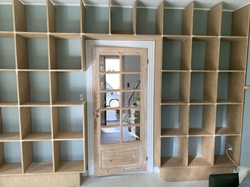 Tømrer udfører udskiftning af døre og montering af indbygget reol som del af tømrerarbejde i bolig